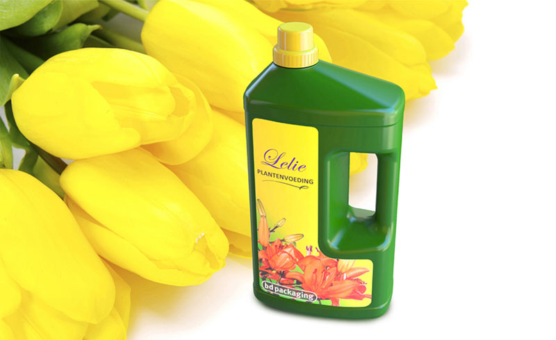 Deep green plastic bottle of plant nutrition with yellow cap and yellow tulips in the background