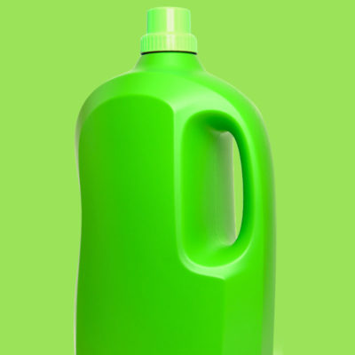 Large bright green plastic bottle with grip hole on green background