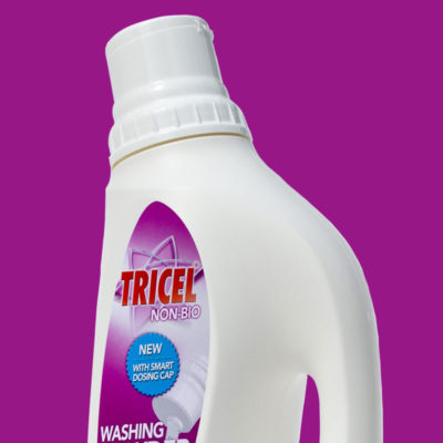 White plastic washing powder bottle with dosing cap on purple background